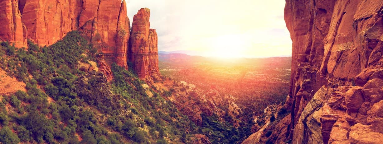 Sunset over a majestic canyon with towering red rock formations.