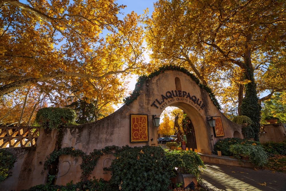 A charming entrance to Tlaquepaque, surrounded by vibrant autumn leaves.