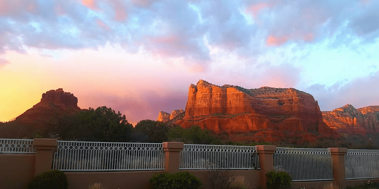Pastel colored sunset sky behind giant Arizona Red Rocks