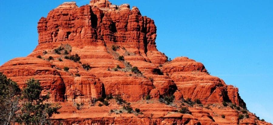 Red rock formation against a clear blue sky.