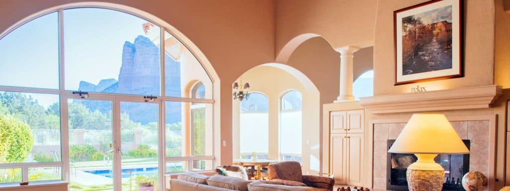 A cozy living room with large windows showcasing a scenic mountain view.